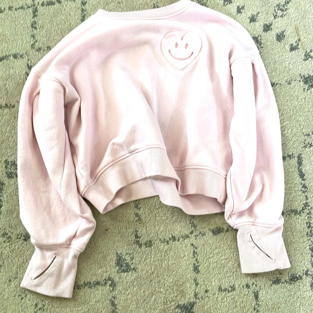 Pink sweat shirt with smile heart on the side of it